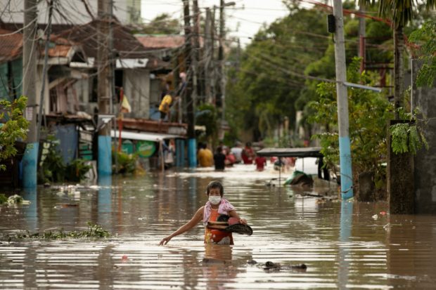 Residents wade through waist-deep flood waters after Typhoon #KardingPH, in San Miguel, Bulacan province on Monday (Sept. 26) REUTERS