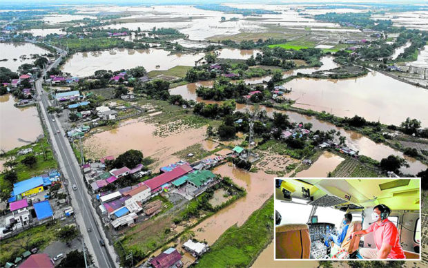 VIEW FROM ABOVE Large sections of residential and farming areas in San Miguel town, Bulacan province, remain underwater on Monday as Supertyphoon “Karding” exits the landmass of Luzon. Inset shows President Marcos during an aerial inspection that brought him to typhoon-hit areas in Bulacan, Nueva Ecija, Aurora and Quezon. GRIG C. MONTEGRANDE/BONGBONG MARCOS FACEBOOK PAGE