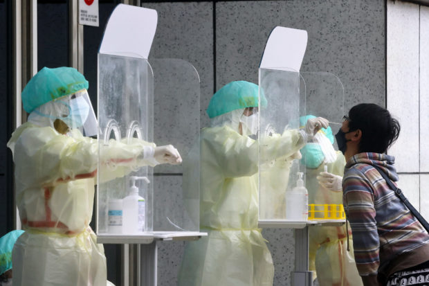 FILE PHOTO: A person gets a coronavirus disease (COVID-19) test in Taipei, Taiwan, May 24, 2022. REUTERS/Ann Wang