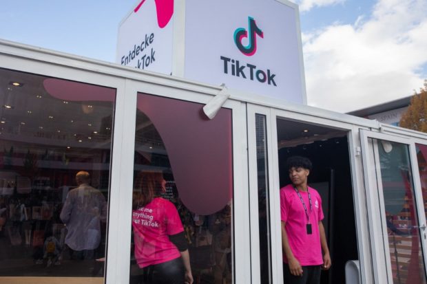 Employees stand at the entrance of a TikTok booth at the Messe fairground during the 23rd Frankfurt Book Fair in Frankfurt am Main on October 22, 2022. STORY: Literature finds unlikely platform in TikTok