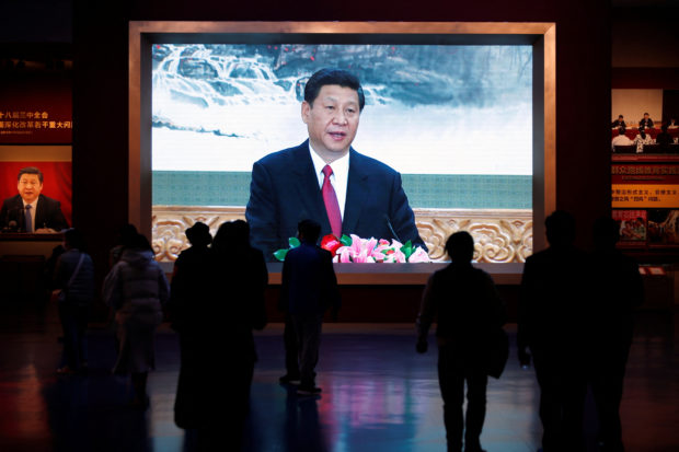 Visitors walk past a screen showing Chinese President Xi Jinping at the Museum of the Communist Party of China in Beijing, China October 13, 2022. REUTERS/Florence Lo