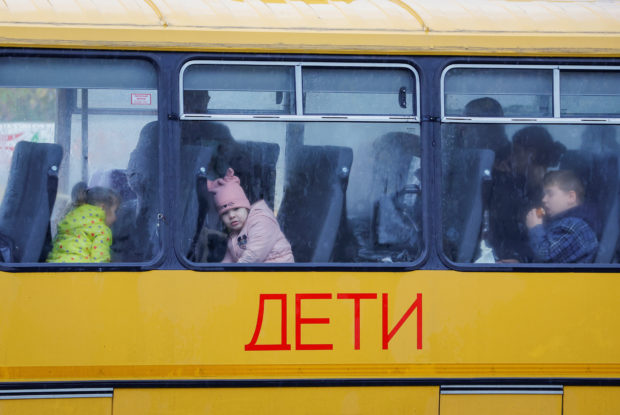 Children evacuated from the Russian-controlled city of Kherson wait in a bus heading to Crimea, in the town of Oleshky, Kherson region, Russian-controlled Ukraine October 23, 2022. REUTERS/Alexander Ermochenko
