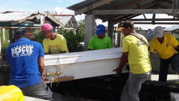 DEATH OF A POOR. Barangay watchmen carry the casket of Avelino Galvan with extreme care after it was damaged by floodwaters. PHOTO COURTESY OF JOSELYN RAMOS