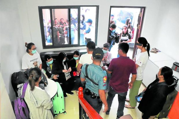 FORCED TO SCAM OTHERS Police officers from the Women and Children Protection Center assist some of the 29 victims—23 Burmese and six Chinese—of alleged human trafficking who were forced to work as scammers for an online gaming operator. They were rescued on Thursday from their Parañaque City dormitory. —PNP-PIO PHOTO