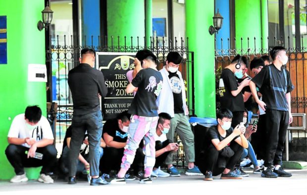 FOREIGN WORKERS In this photo taken in February 2020, Chinese citizens working for Philippine offshore gaming operators gather at the Bureau of Immigration office in Manila to process their documents. STORY: DOJ alarmed over spread of STDs among POGO workers