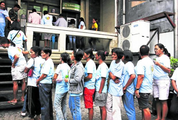 Beneficiaries of the 4Ps poverty alleviation program in Lucena City form a long line to the ATM kiosk of a Land Bank of the Philippines branch in Lucena City