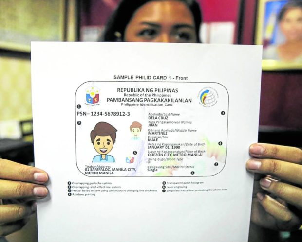 A congressional worker shows a sample of the PhilSys ID presented to the House of Representatives. STORY: Gov’t issues temporary PhilSys ID cards on paper