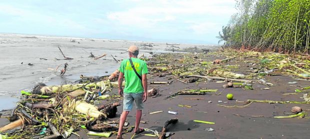Man on a beach on Tayabas Bay after Typhoon Paeng. STORY: Empower communities vs climate change through risk management – experts