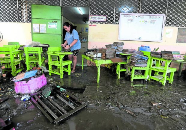 CLEANUP TASK A teacher cleans a classroom at Ambrosio Robles Elementary School in Noveleta, Cavite, as floodwaters triggered by heavy rains dumped by Severe Tropical Storm “Paeng” start to recede on Monday. Full in-person classes in the country’s public schools will resume on Nov. 2. —MARIANNE BERMUDEZ