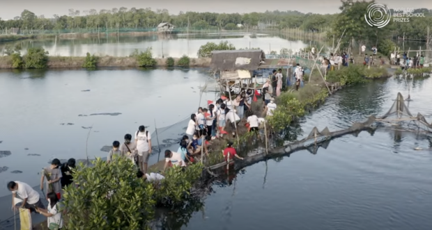 Students and teachers from Bonuan Buquig National High School in Dagupan City replant mangroves after their community was devastated by Typhoon Pepeng.