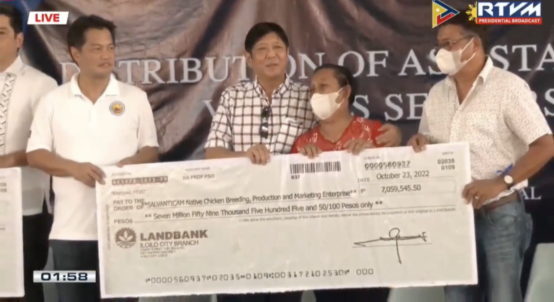 DA turns over a P7 million symbolic cheque to a farmer organization, total aid distributed amounted to P88 million. | Screengrab from PTV Live marcos aid distribution talisay