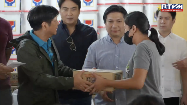 President Ferdinand "Bongbong" Marcos Jr. (left) distributes relief goods to people affected by Tropical Storm Paeng in Noveleta, Cavite on Monday, October 31. Screengrab from RTVM Facebook