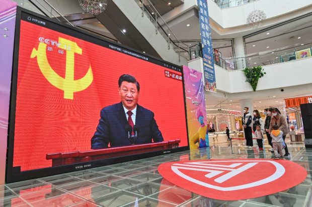 People watch a live broadcast of China's President Xi Jinping speaking during the introduction of the Communist Party of China's Politburo Standing Committee, on a screen at a shopping mall in Qingzhou in China's eastern Shandong province on October 23, 2022. (Photo by AFP) / China OUT