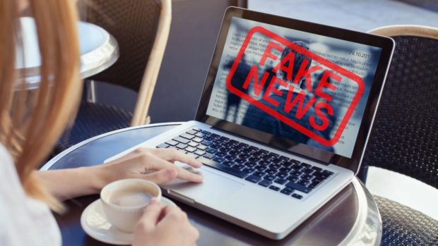Stock image. Open laptop with "FAKE NEWS" superimposed over screen. STORY: 9 of 10 Filipinos consider fake news a problem