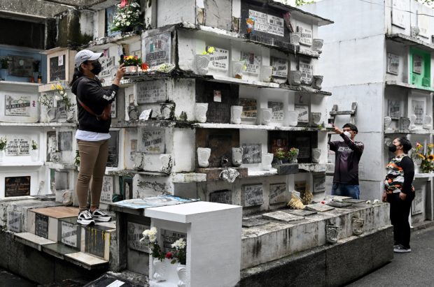 Filipinos clutching flowers and umbrellas pour into cemeteries across the Catholic-majority Philippines on All Saints' Day, November 1, 2022