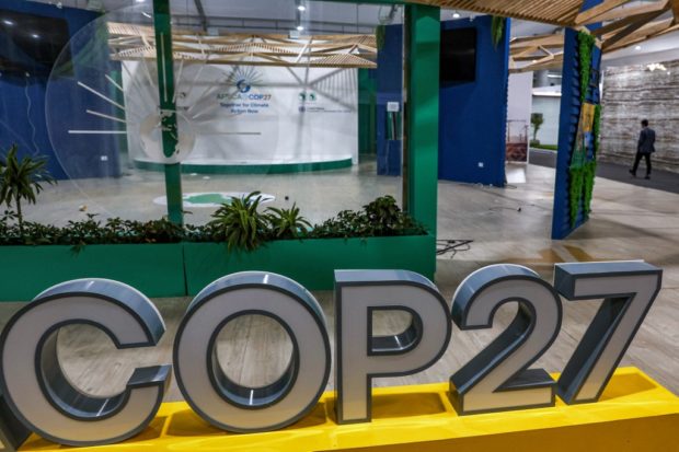 A person walks near the COP27 climate conference at the deserted hall at the Sharm el-Sheikh International Convention Centre, in Egypt's Red Sea resort city of the same name near the end of the climate conference on November 19, 2022. (Photo by AHMAD GHARABLI / AFP)