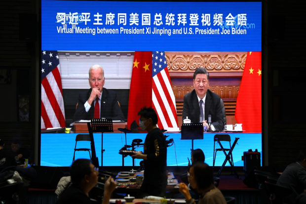 A screen shows Chinese President Xi Jinping attending a virtual meeting with U.S. President Joe Biden via video link, at a restaurant in Beijing, China November 16, 2021. REUTERS/Tingshu Wang/File Photo