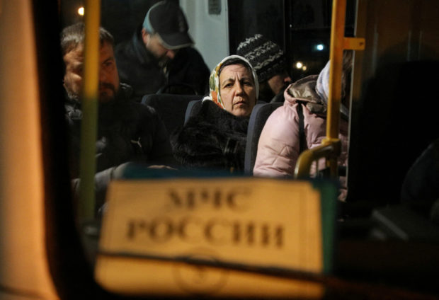 Civilians evacuated from the Russian-controlled part of Kherson region of Ukraine sit inside a bus as they arrive at a local railway station in the town of Dzhankoi, Crimea November 10, 2022. REUTERS/Alexey Pavlishak