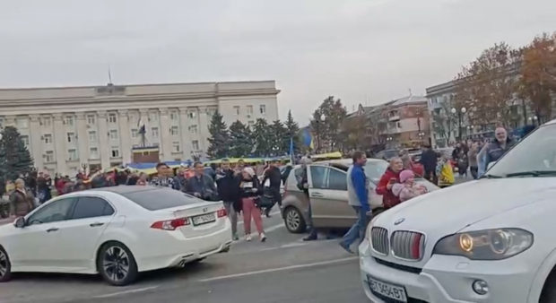 Crowd cheer and chant as they surround a car with Ukrainian soldiers in Kherson Freedom Square, Ukraine in this screen grab obtained from a video released on November 11, 2022. Video obtained by Reuters/Handout via REUTERS