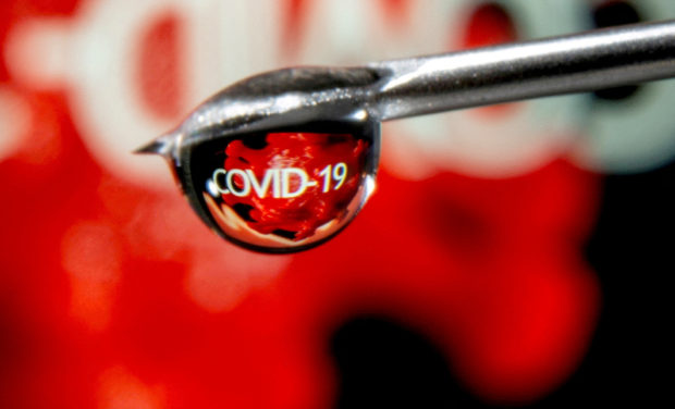 he word "COVID-19" is reflected in a drop on a syringe needle in this illustration taken November 9, 2020. REUTERS/Dado Ruvic/Illustration/File Photo