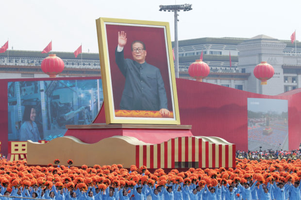 Performers travel past Tiananmen Square next to a float showing former Chinese president Jiang Zemin during the parade marking the 70th founding anniversary of People's Republic of China, on its National Day in Beijing, China October 1, 2019. REUTERS/Jason Lee/File Photo