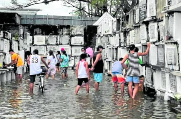 More than 100 public and private cemeteries in Pampanga like this one in Minalin town are flooded on Nov. 1 following Severe Tropical Storm Paeng’s (international name: Nalgae) heavy rains, leaving many tombs unattended or abandoned or prompting people to wade in murky waters on the feast of the dead. STORY: Bulacan, Pampanga folk brave flooded cemeteries to visit kin
