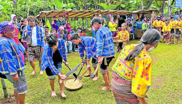  Under the watchful eyes of their elders, a group of Bagobo Klata youth performs a traditional dance depicting hunting and gathering for food