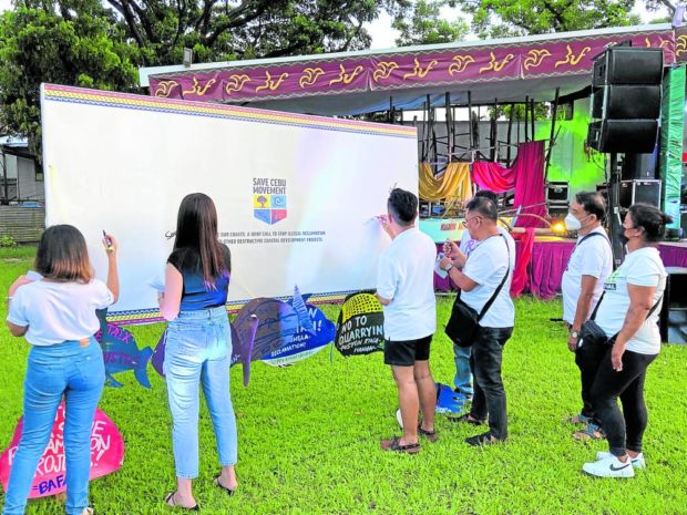 SIGN HERE People from different groups sign the manifesto against the reclamation projects in Cebu during the launching of the Save Cebu Movement at the University of the Philippines Cebu campus in Barangay Lahug, Cebu City, on Saturday. —PHOTO COURTESY OF OCEANA PHILIPPINES