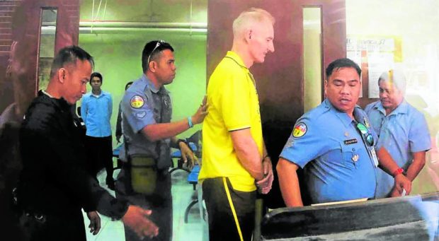 CONVICTED In this 2018 photo, convicted child abuser Peter Gerard Scully (middle, in yellow shirt) is escorted by police officers out of the courtroom following his sentencing. —JIGGER J. JERUSALEM
