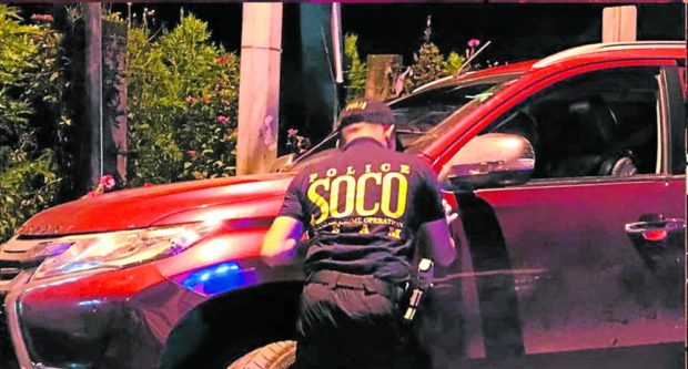 CRIME SCENE A policeman from the Cotabato City police’s Scene of the Crime Operation inspects the car of an Army officer assigned to the Office of the Presidential Adviser on Peace, Reconciliation and Unity who was ambushed in Cotabato City on Saturday. —VOICE FM COTABATO photo