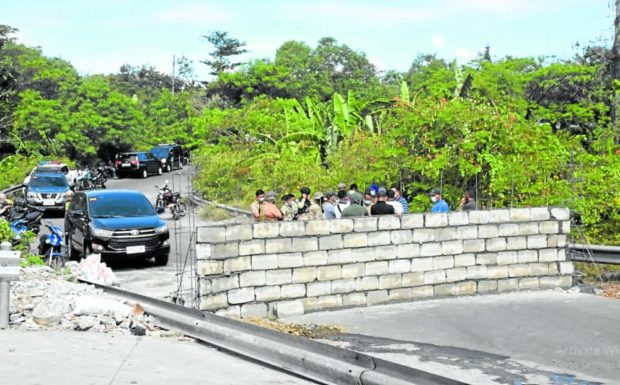 Residents and local officials check out the concrete wall erected across Insular Road by the Bureau of Corrections supposedly for security reasons. STORY: BuCor to tear down concrete barriers along NBP roads