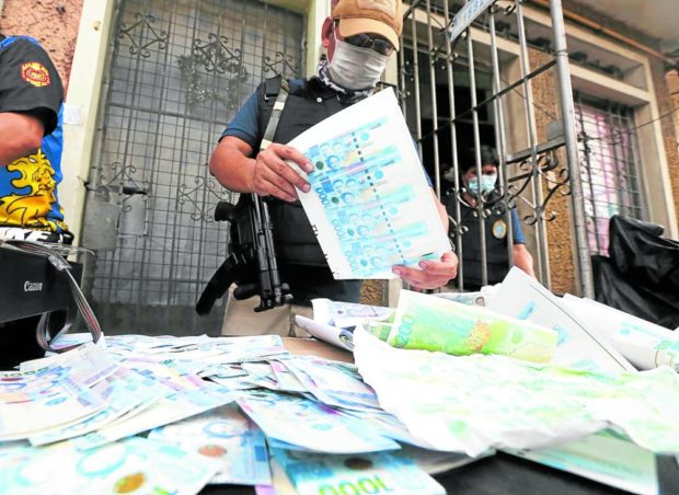 In this December 2020 file photo, fake 1,000 peso bills were seized from three men who were printing them inside an apartment in Manila after a raid by police and personnel of the Bangko Sentral ng Pilipinas. STORY: Public warned vs fake bills this holiday season