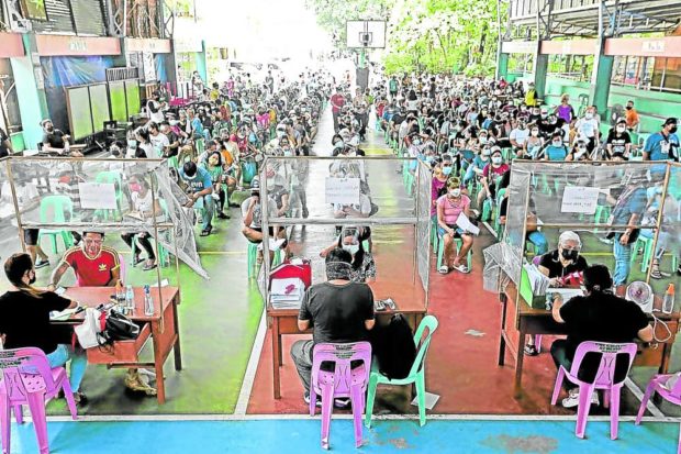 DOLE-OUT Residents queue to receive financial aid from the national government at Andres Bonifacio Elementary School in Pasay City in this file photo. —FILE PHOTO 