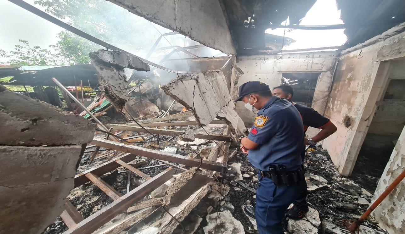 A policeman inspects the area in Calamba City, Laguna province that was destroyed by a fire on Friday (Nov. 18), leaving at least five people dead. 