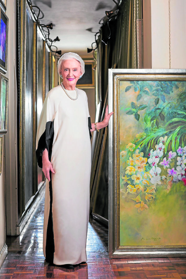 The artist beside one of her floral paintings