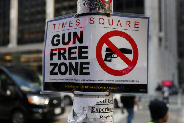 FILE PHOTO: Times Square Gun Free Zone sign hangs from a light pole on 6th avenue in New York City