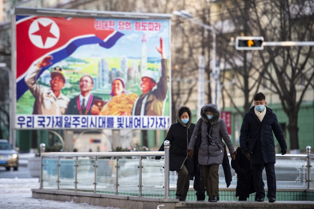 People walk in a street in central Pyongyang on December 23, 2022. (Photo by KIM Won Jin / AFP) NORTH KOREA BALLISTIC MISSILES