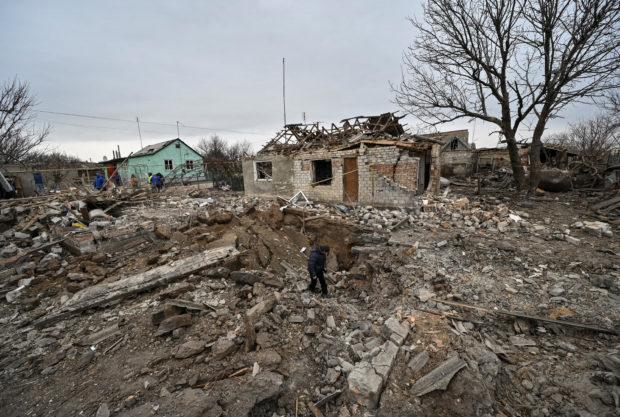A local resident inspects a crater left by a Russian military strike, as their attack in Ukraine continues, in the village of Kupriianivka, Zaporizhzhia region, Ukraine December 7, 2022.  REUTERS/Stringer