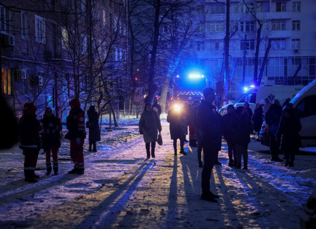 Local residents gather near a building destroyed by a Russian drone attack, as their attack on Ukraine continues, in Kyiv, Ukraine December 14, 2022. REUTERS/Gleb Garanich
