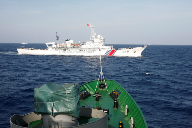 A ship (top) of the Chinese Coast Guard is seen near a ship of the Vietnam Marine Guard in the South China Sea, about 210 km (130 miles) off shore of Vietnam May 14, 2014. REUTERS/Nguyen Minh/File Photo