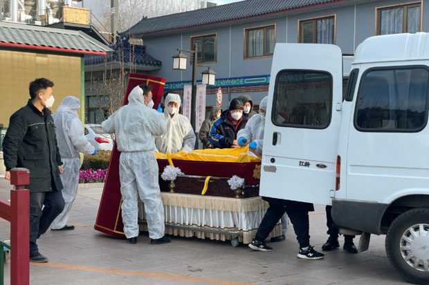 Workers in protective suits transfer a body in a casket at a funeral home, amid the coronavirus disease (COVID-19) outbreak in Beijing, China December 17, 2022. REUTERS/Alessandro Diviggiano