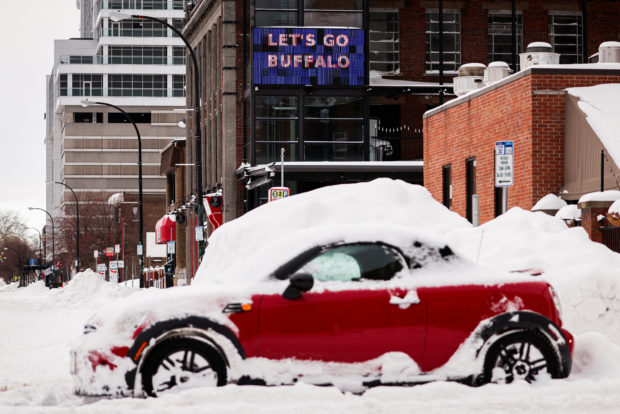 A "let’s go Buffalo" sign is seen behind an abandoned car on the road following a winter storm in Buffalo, New York, U.S., December 27, 2022. REUTERS/Lindsay DeDario