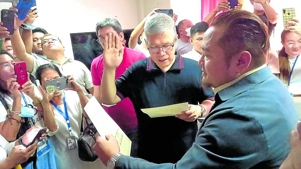 Albay Vice Gov. Edcel “Grex” Lagman takes his oath of office as governor before lawyer Ian Macasinag, dean of the College of Law of Bicol College, on Thursday.