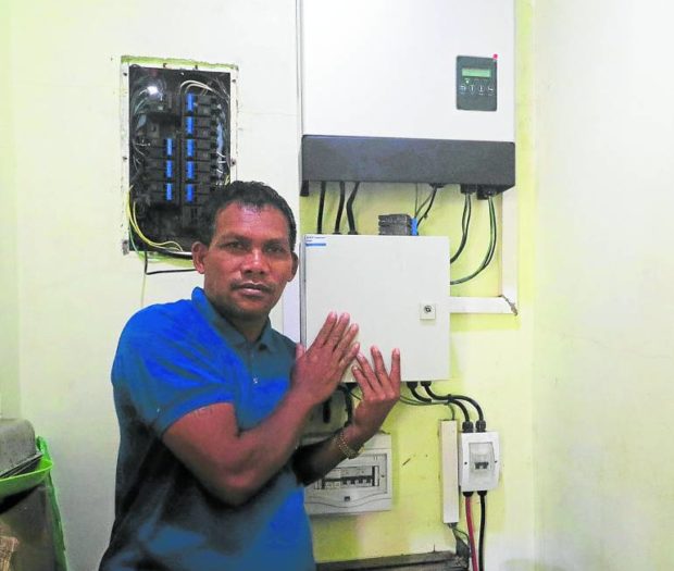 Village chief Roberto Itdang of Barangay Salaysay, Davao City, shows the panel board belowt he inverter, which converts the direct current from the solar panels to alternative current that runs the appliances. 