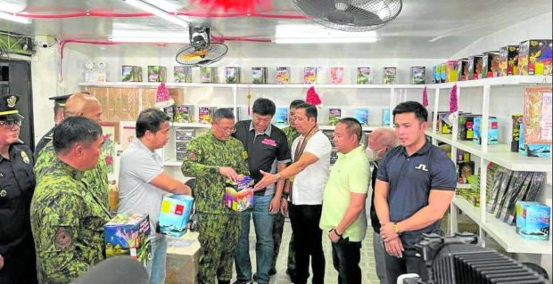 Philippine National Police Chief Director General Rodolfo Azurin Jr. (fourth from left), Bulacan Gov. Daniel Fernando (third from right) and other police and Bulacan officials inspect the pyrotechnic products produced and sold by the Ding Dinglasan's store in Turo Pyrozone in Bocaue town on Thursday. The store has minimal display of stocks of products due to the scarcity of imported materials to make pyrotechnics and firecrackers. STORY: Prices of firecrackers in Bulacan soar