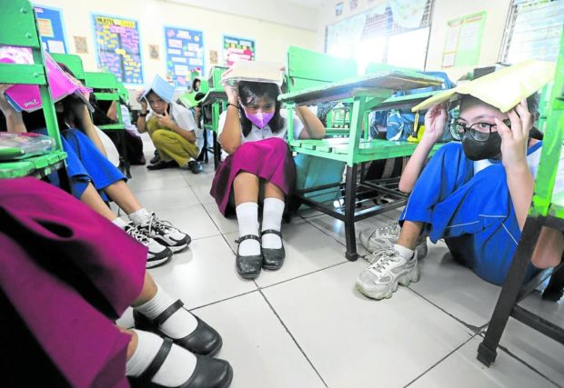 Grade 6 pupils take part in the “duck, cover, hold” exercise at Rafael Palma Elementary School in Manila on Nov. 10, 2022. STORY: DepEd’s ‘surprise’ quake, fire drills have a schedule
