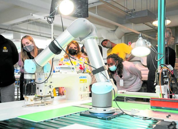  A robotic arm positions pieces of stiffened fabric for a demonstration of automated sewing at the Industrial Sewing and Innovation Center in Detroit, Michigan, United States. STORY: Robots set sights on new job: Sewing blue jeans
