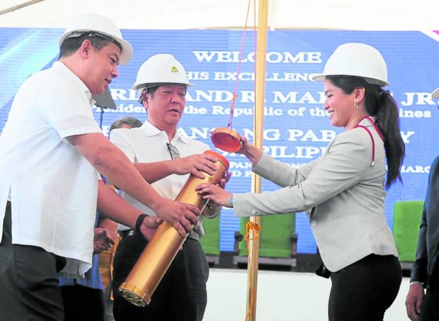 President Marcos and Palayan City Mayor Nicole Cuevas seal the time capsule for a housing project along with Speaker Martin Romualdez (left). STORY: Housing plan pushed with 100-year leases