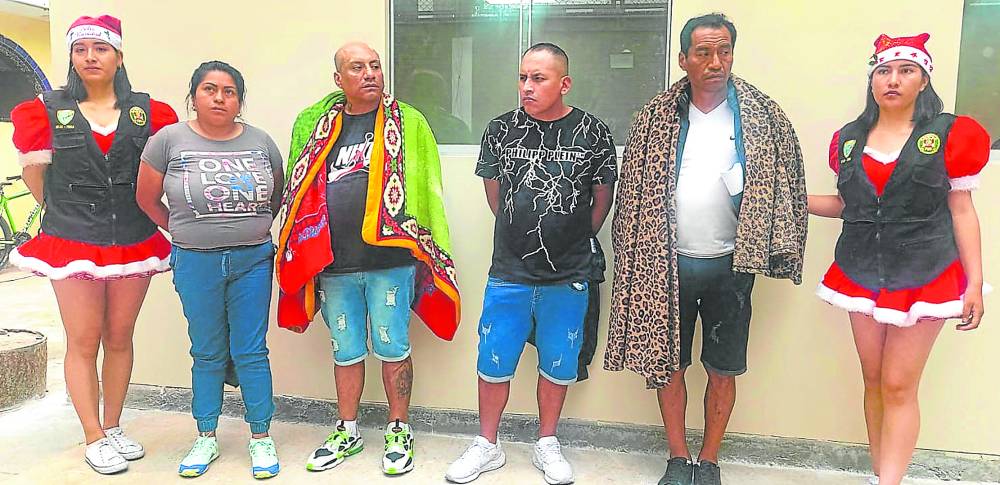  Four suspected cocaine sellers are flanked by two of the arresting officersin Christmas costume at a police station in the Peruvian capital of Lima