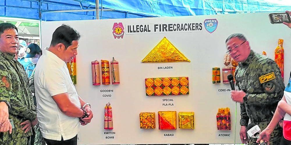 Philippine National Police Chief Gen. Rodolfo Azurin Jr. (right) shows the various kinds of prohibited firecrackers